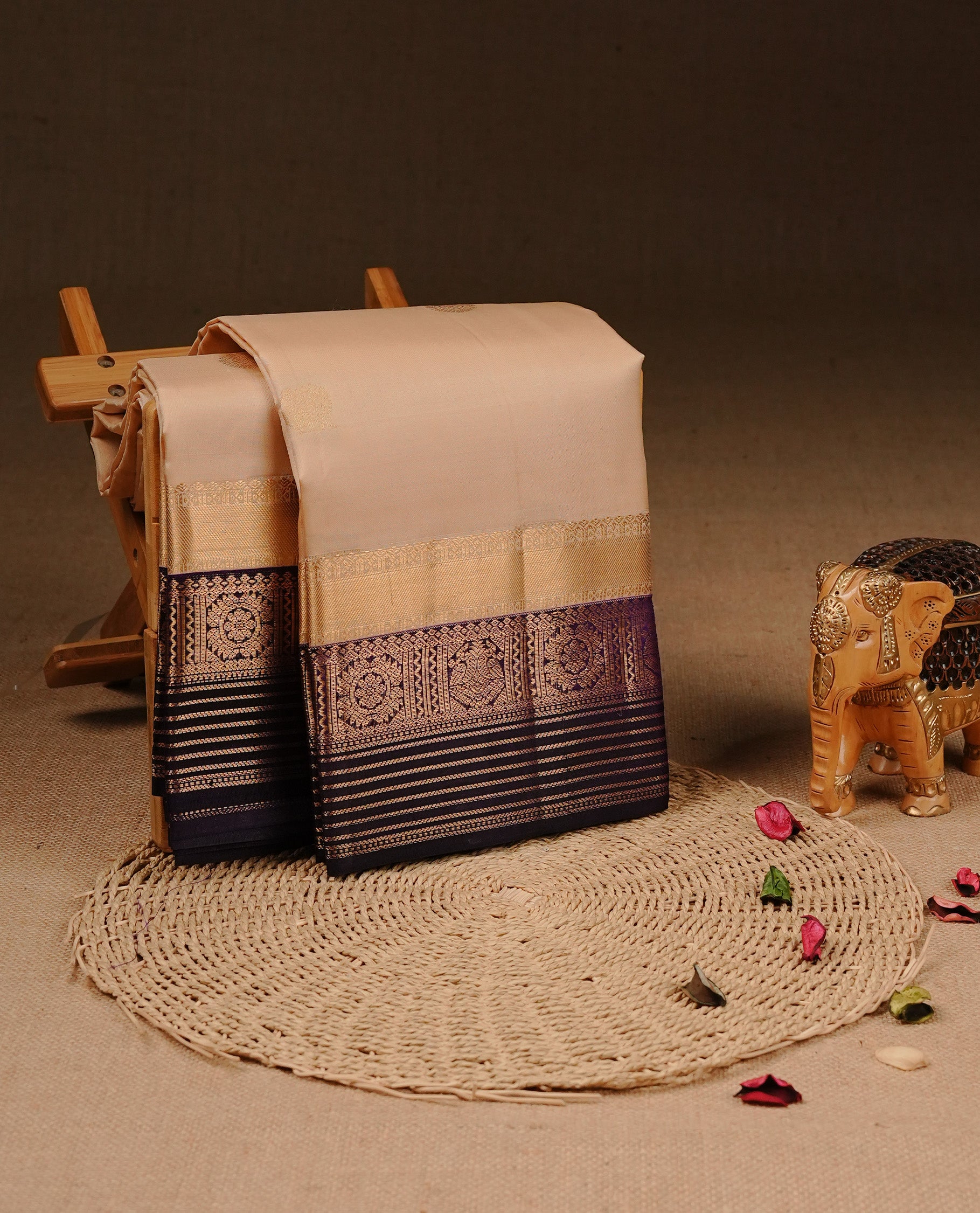 Cream colour Traditional Kancheepuram silk saree featuring gold zari motifs on body, enhanced with contrast purple with traditional border, paired with matching blouse piece.