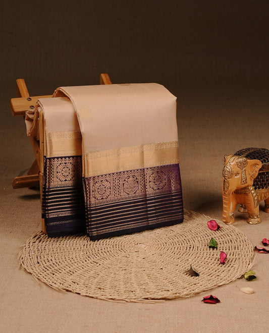 Cream colour Traditional Kancheepuram silk saree featuring gold zari motifs on body, enhanced with contrast purple with traditional border, paired with matching blouse piece.