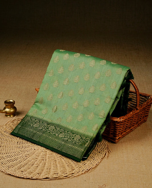 Pista green colour banaras silk saree featuring gold zari buttas on body, complemented by contrast Dark green with gold zari border, comes with matching blouse piece.