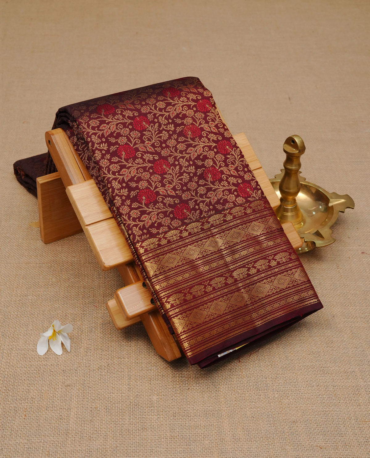 Chocolate Colour Pure Wedding silk saree featuring Gold zari Floral kodi pattern worked body, complemented by self colour with traditional border, comes with matching blouse piece.