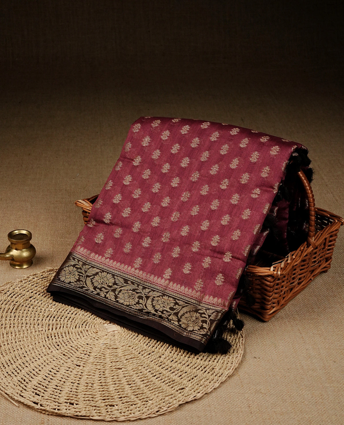 Maroon colour Banaras silk saree featuring gold zari buttas on body, complemented by contrast chocolate colour border, comes with matching blouse piece.