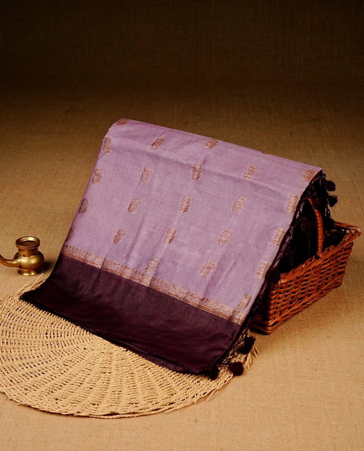 Light purple colour banaras silk saree featuring Gold zari buttas on body, complemented by contrast Purple colour border, comes with matching blouse piece.
