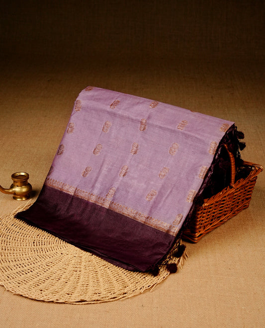 Light purple colour banaras silk saree featuring Gold zari buttas on body, complemented by contrast Purple colour border, comes with matching blouse piece.