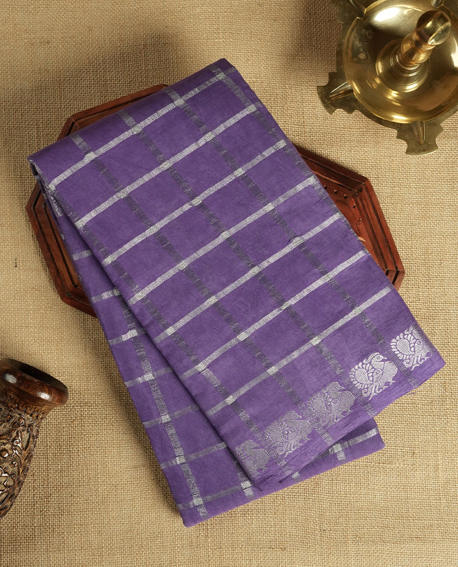 Purple colour Chettinad cotton saree featuring silver checked patterns on the body, accentuated with elegant silver peacock motifs along the border & Comes with a matching blouse piece.