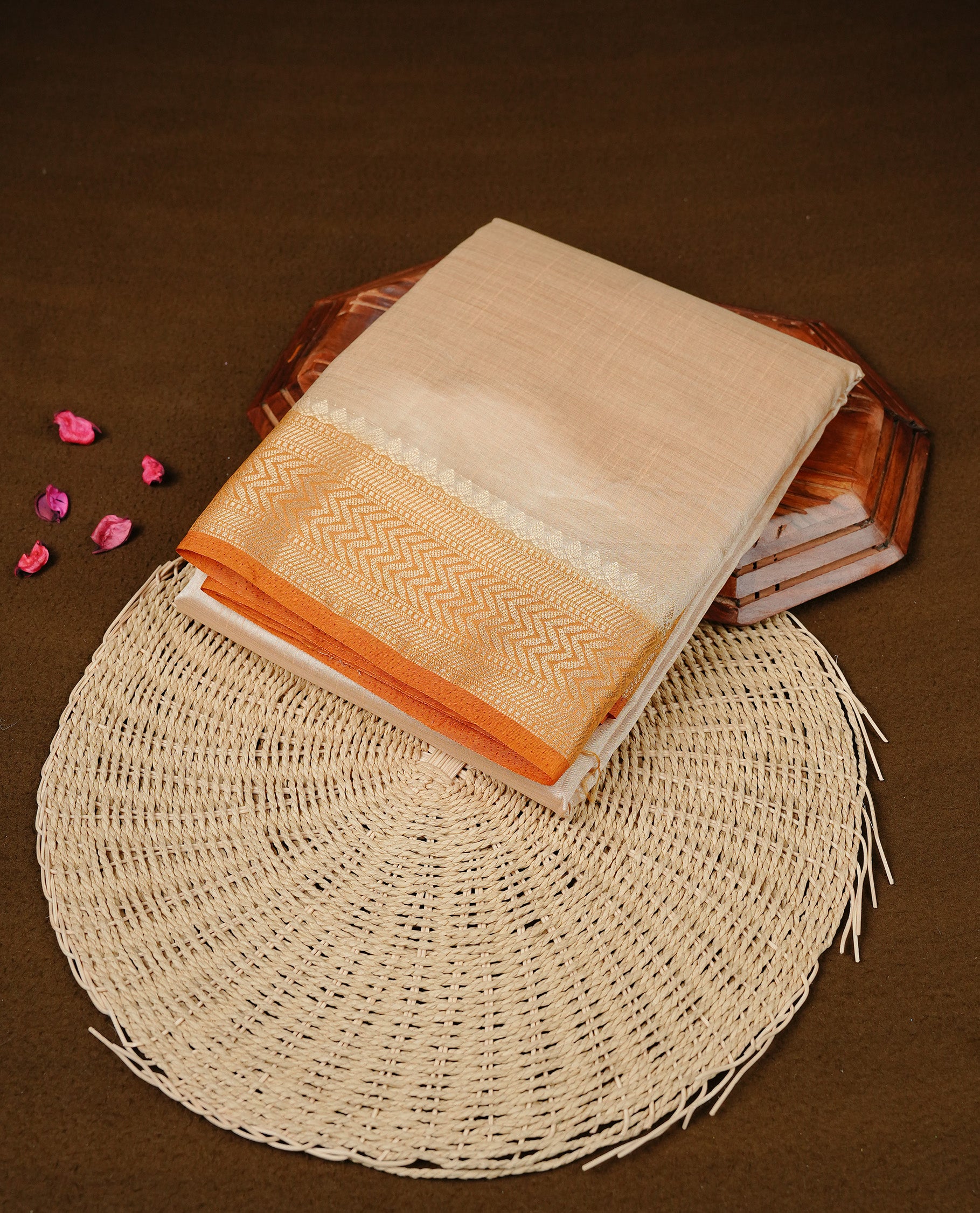 Cream colour Semi Tussar silk saree featuring an elegant plain body, accentuated by a contrast Mustard border adorned with intricate gold zigzag zari work, paired with a matching blouse piece.