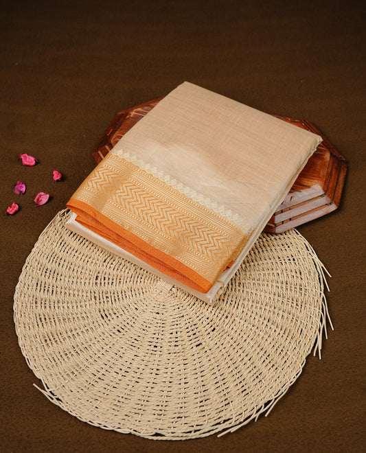 Cream colour Semi Tussar silk saree featuring an elegant plain body, accentuated by a contrast Mustard border adorned with intricate gold zigzag zari work, paired with a matching blouse piece.