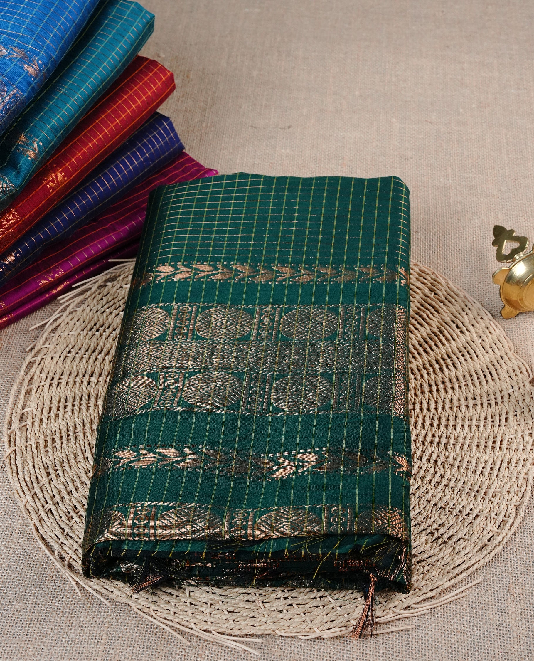 Bottle Green colour Kalyani cotton saree featuring Gold zari checks on body, enhanced with zari border and grand zari pallu, comes with self colour blouse piece.