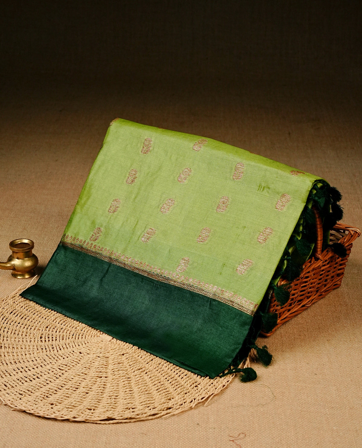 Light green colour banaras silk saree featuring Gold zari buttas on body, complemented by contrast Dark green colour border, comes with matching blouse piece.