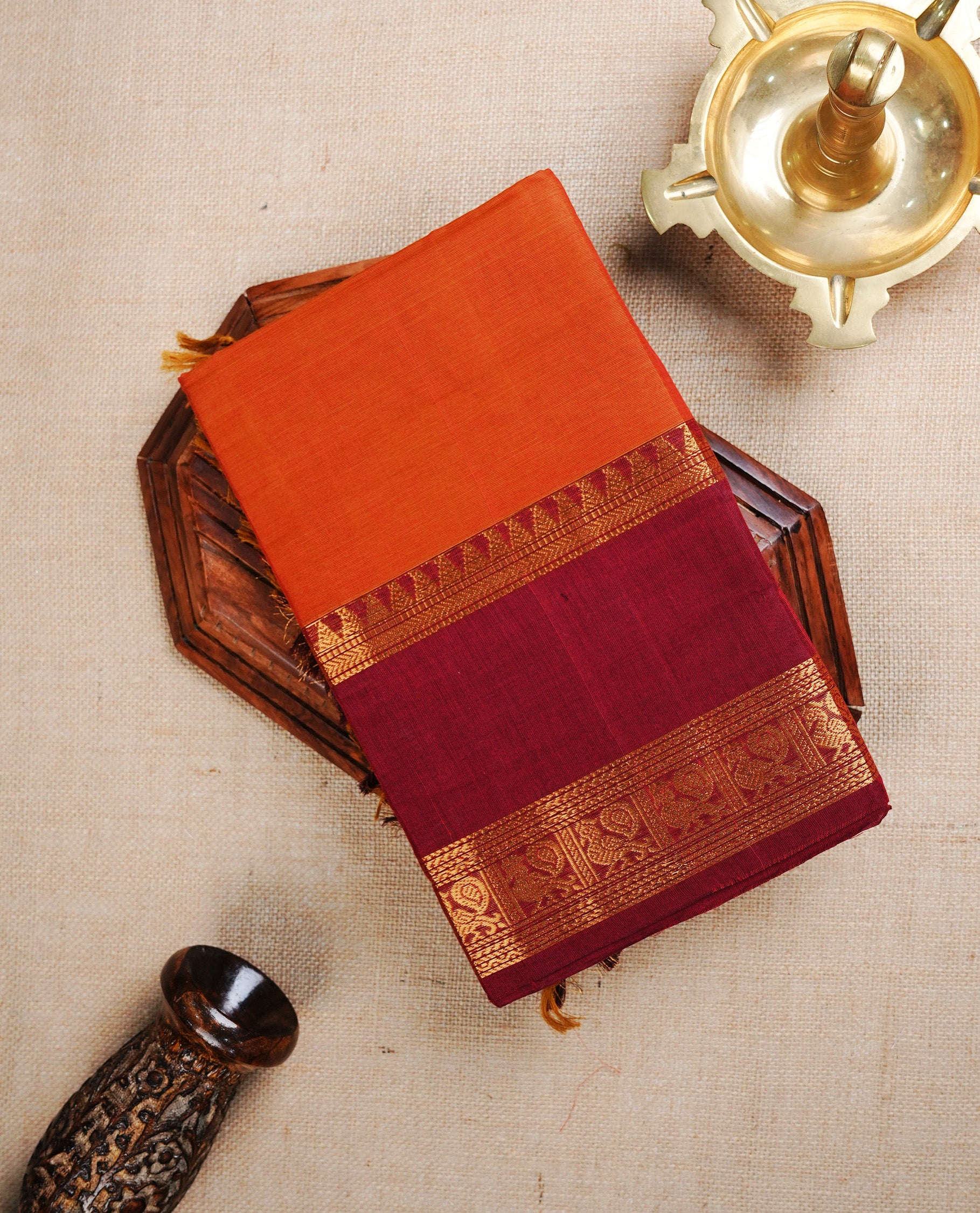 Burnt Orange  colour chettinad cotton saree featuring  a Plain  body, complemented by Contrast  Dark Red Colour With Gold Zari border, paired with matching blouse piece.