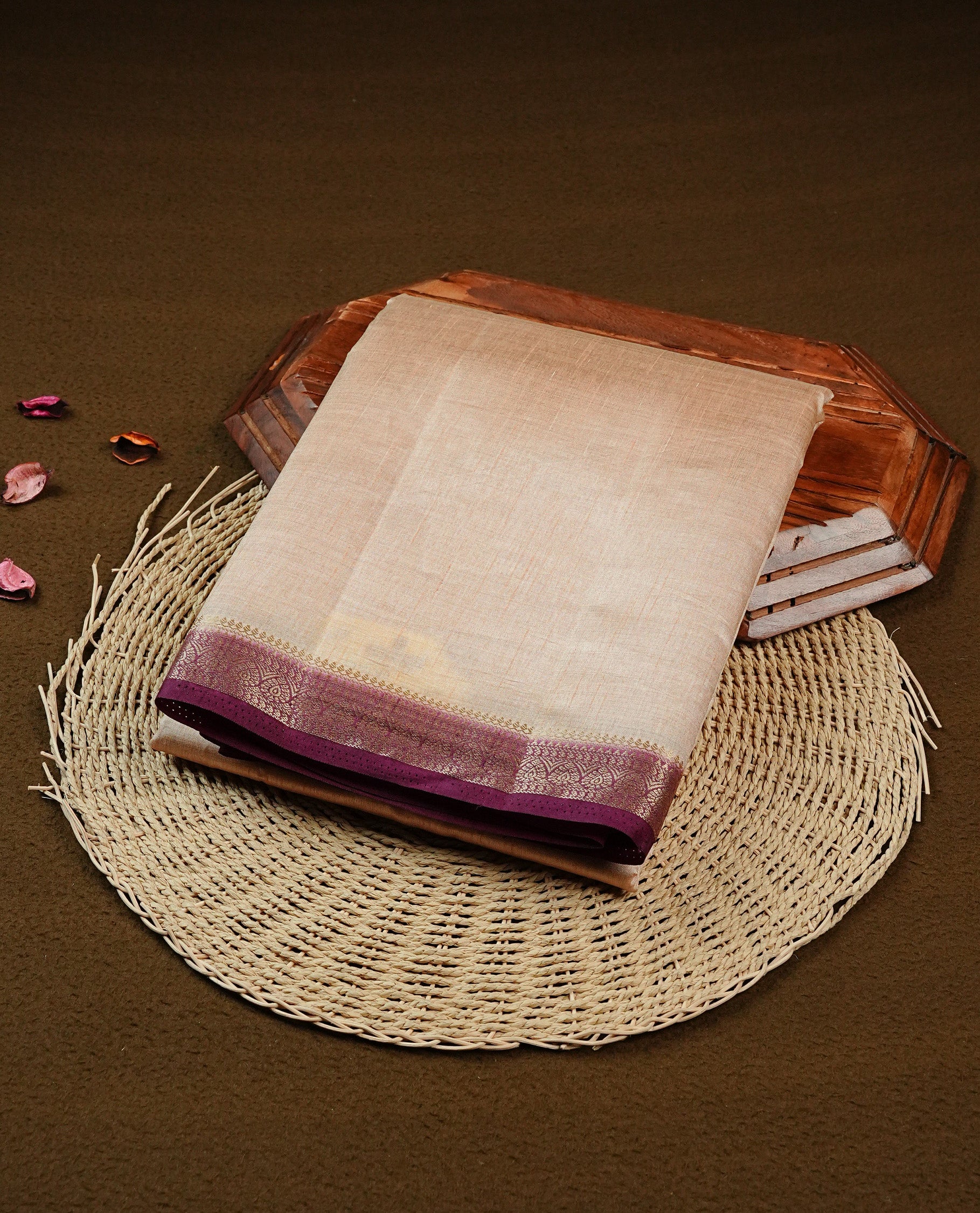 Cream colour Semi Tussar silk saree featuring an elegant plain body, accentuated by a contrast Purple border adorned with intricate gold zari work, paired with a matching blouse piece.
