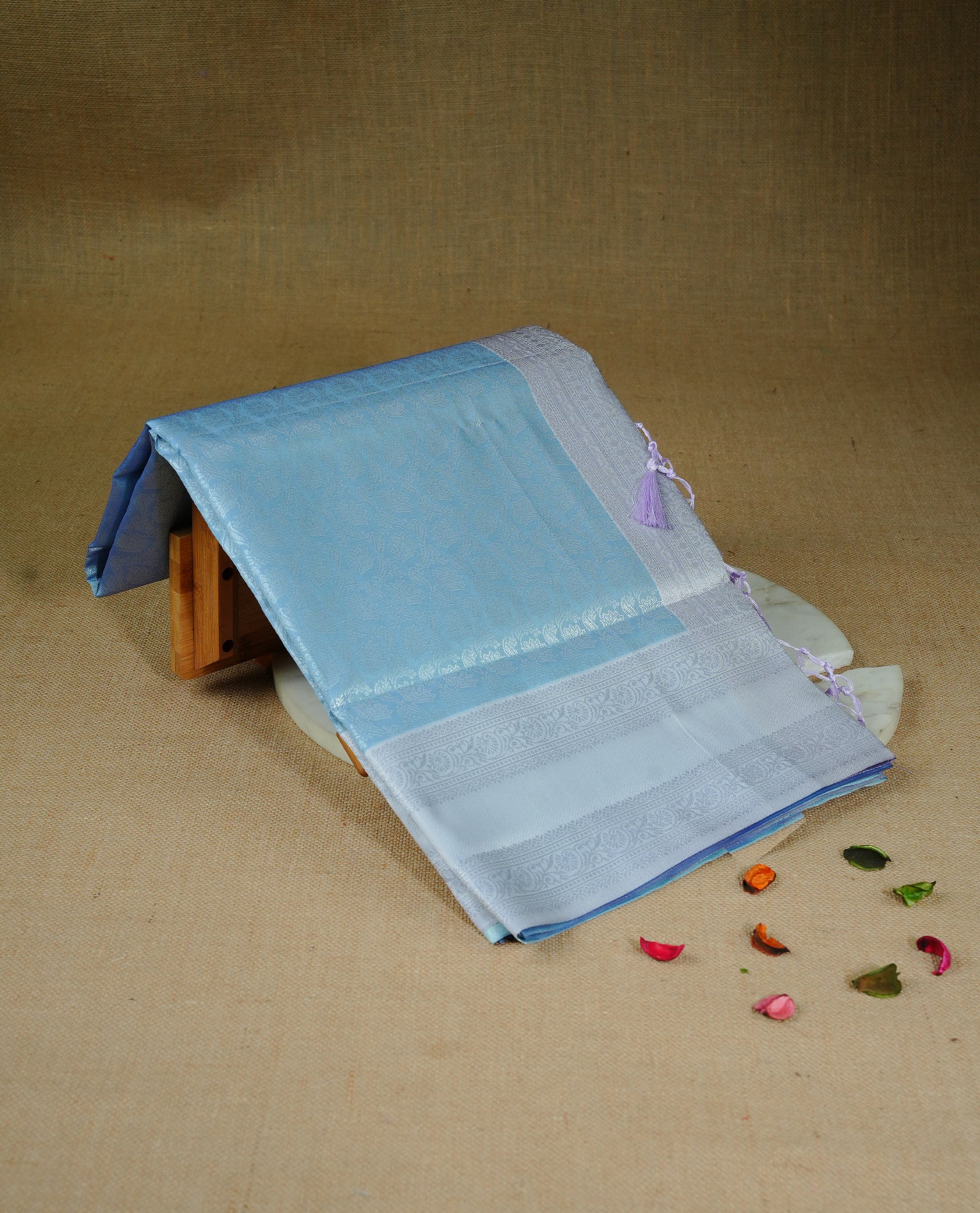 Sky blue colour semi silk saree featuring Silver zari Floral pattern on body, complemented by contrast Grey colour with silver zari border, comes with matching blouse piece.
