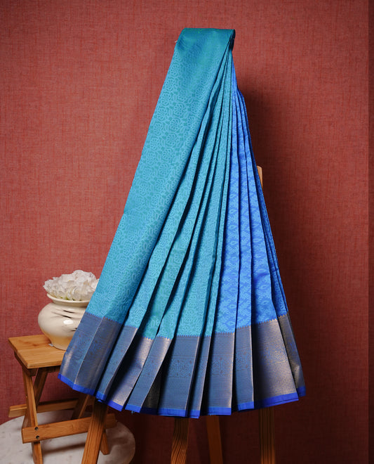 Neon blue colour Semi silk saree Featuring Self colour zari pattern on body, complemented by contrast blue colour with gold zari border, paired with matching blouse piece.