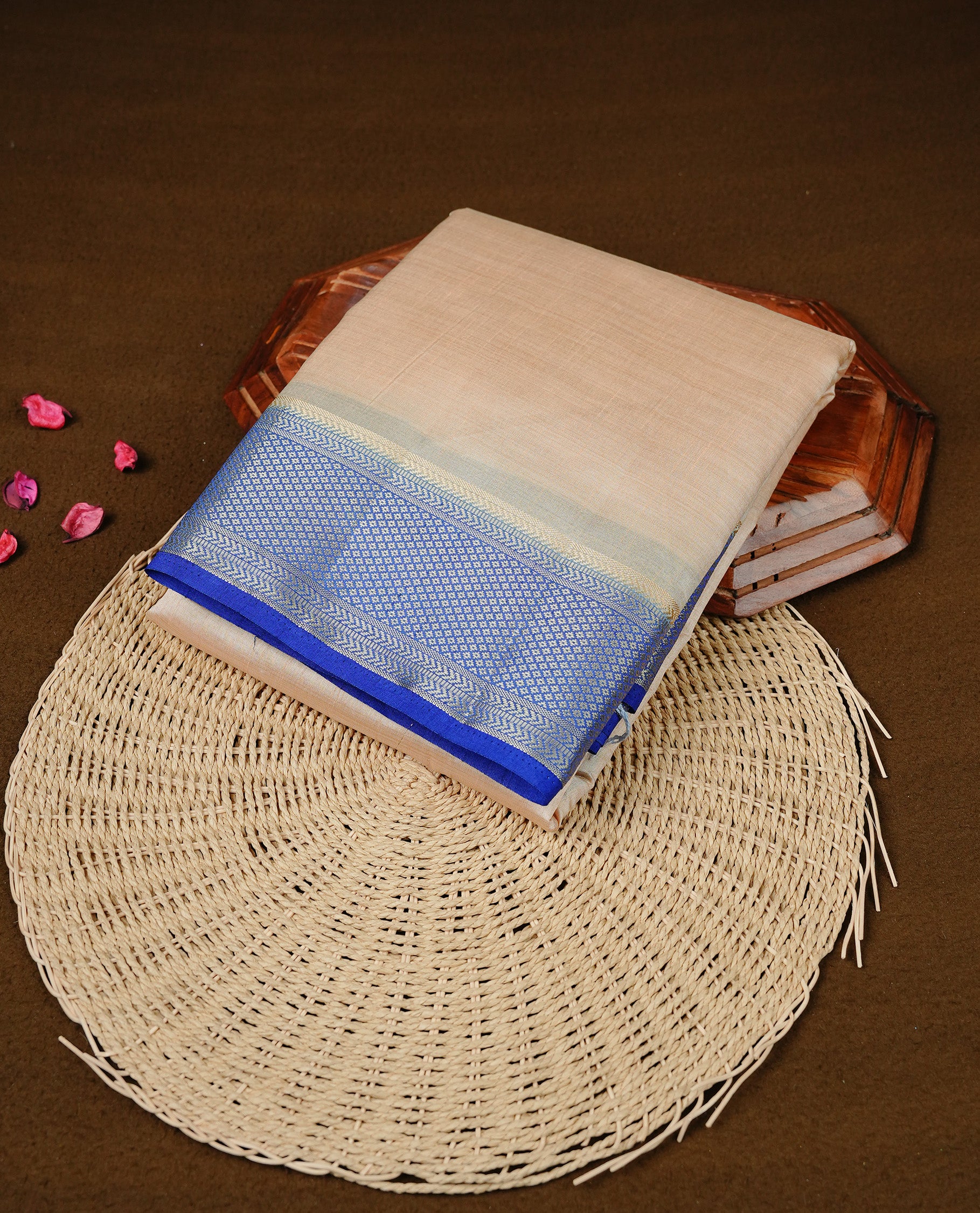 Cream colour Semi Tussar silk saree featuring an elegant plain body, accentuated by a contrast Blue border adorned with intricate gold zari work, paired with a matching blouse piece.