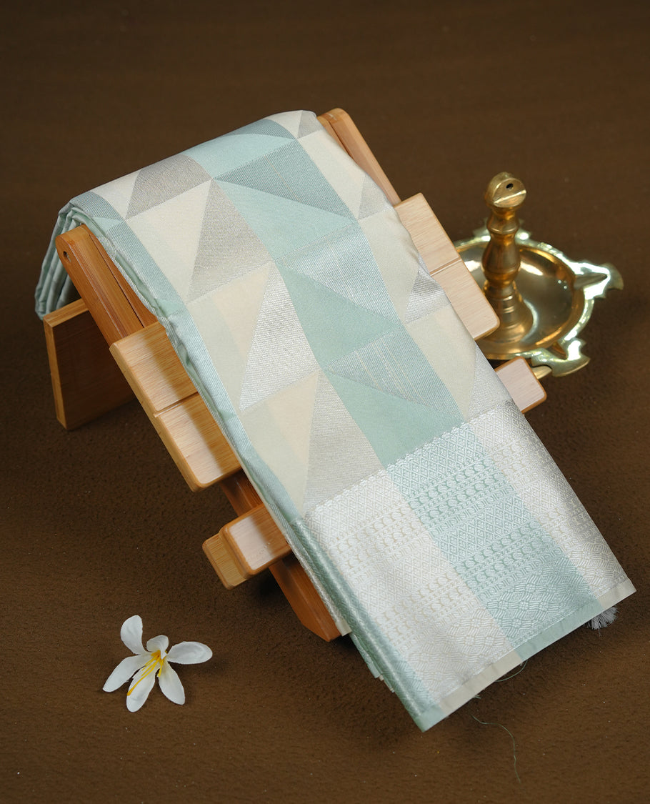 Mint & cream colour semi soft silk saree featuring a silver zari patterned body, complemented by silver zari motifes on pallu & border and a matching blouse piece.