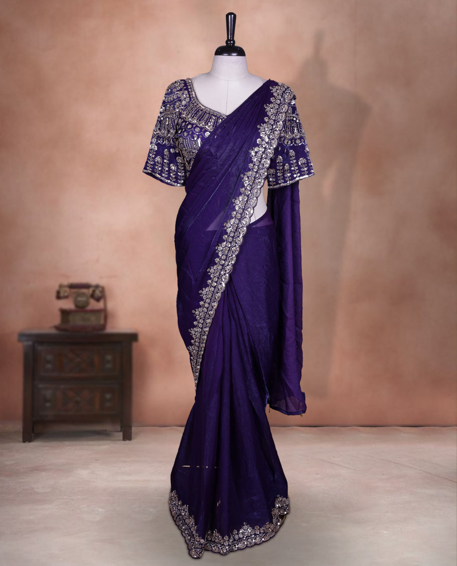 Elegant deep purple colour ready to wear saree adorned with rich gold bead embroidery along the border and pallu, paired with a heavily embellished matching blouse for a grand festive look.