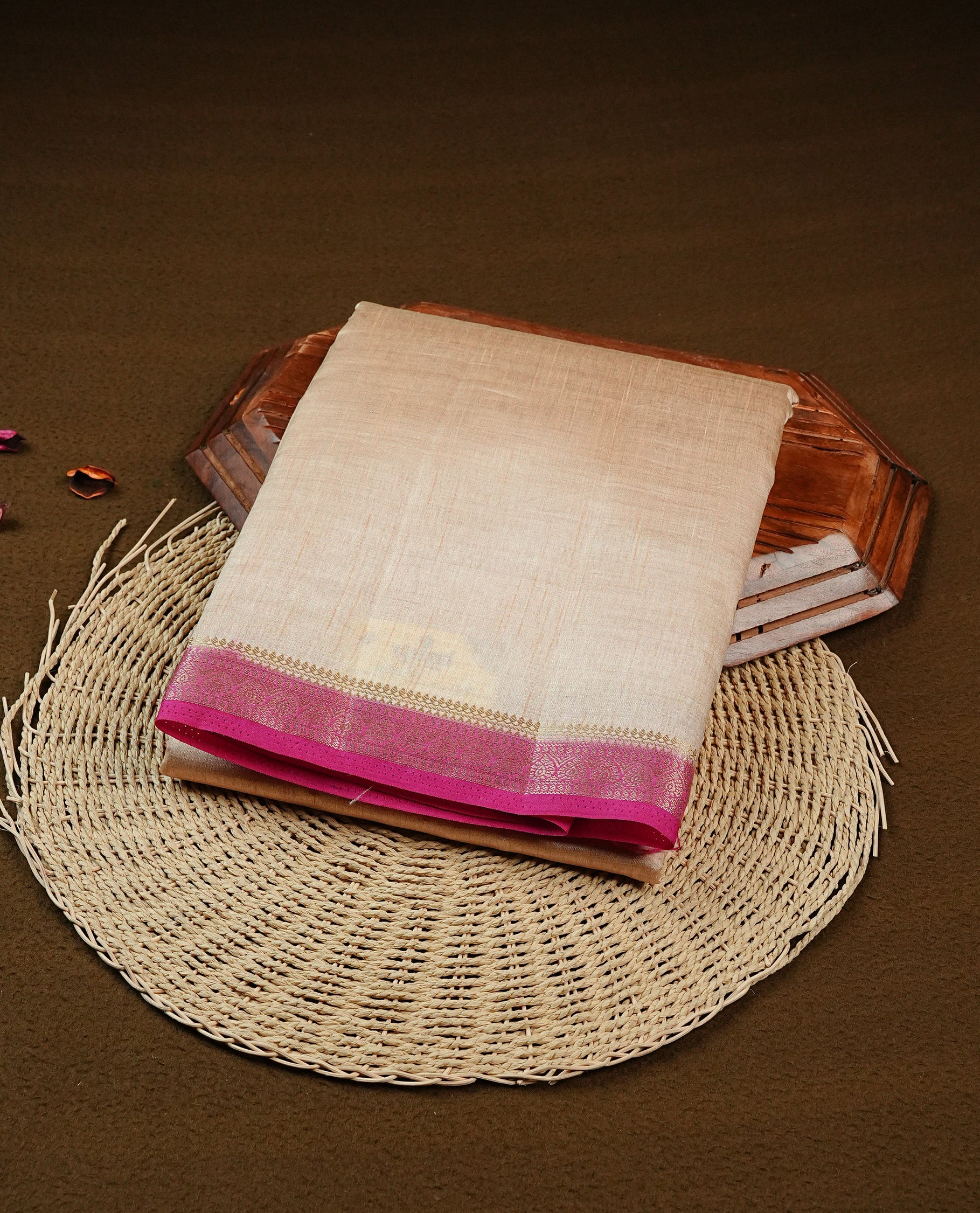 Cream colour Semi Tussar silk saree featuring an elegant plain body, accentuated by a contrast Magenta border adorned with intricate gold zari work, paired with a matching blouse piece.