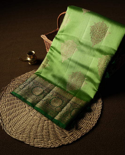 Parrot Green Colour Banaras Soft Silk Saree with Gold Zari Textured Diamond-Shaped Buttas, Simple Decorative Pallu Border, Grand Pallu with Ornate Circular and Floral Motifs in Forest Green and Gold Tones, and Matching Forest Green Blouse.