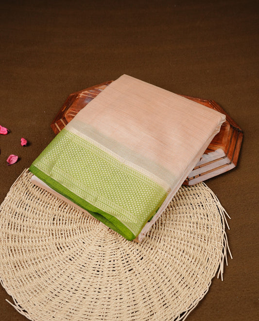 Cream colour Semi Tussar silk saree featuring an elegant plain body, accentuated by a contrast olive border adorned with intricate gold zari work, paired with a matching blouse piece.