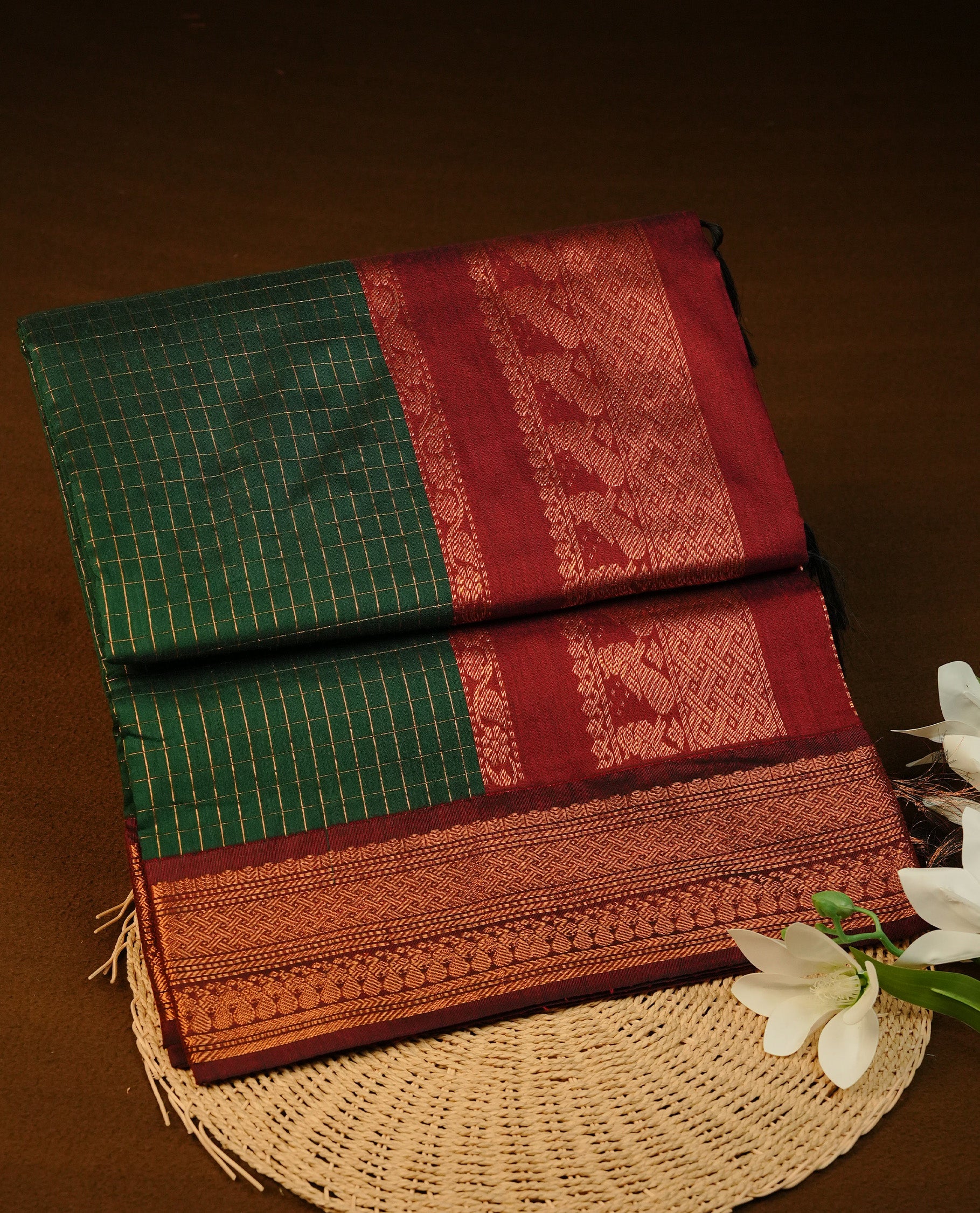 Green colour Kalyani cotton saree featuring Gold zari check pattern on body, complemented by Contrast Maroon colour with grand gold zari border & pallu, matching blouse piece