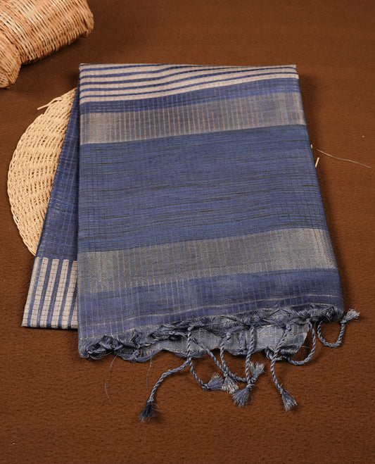 Blue colour semi tussar silk saree with fine striped texture and a subtle geometric body design. Finished with a classic striped pallu and tassel edges.