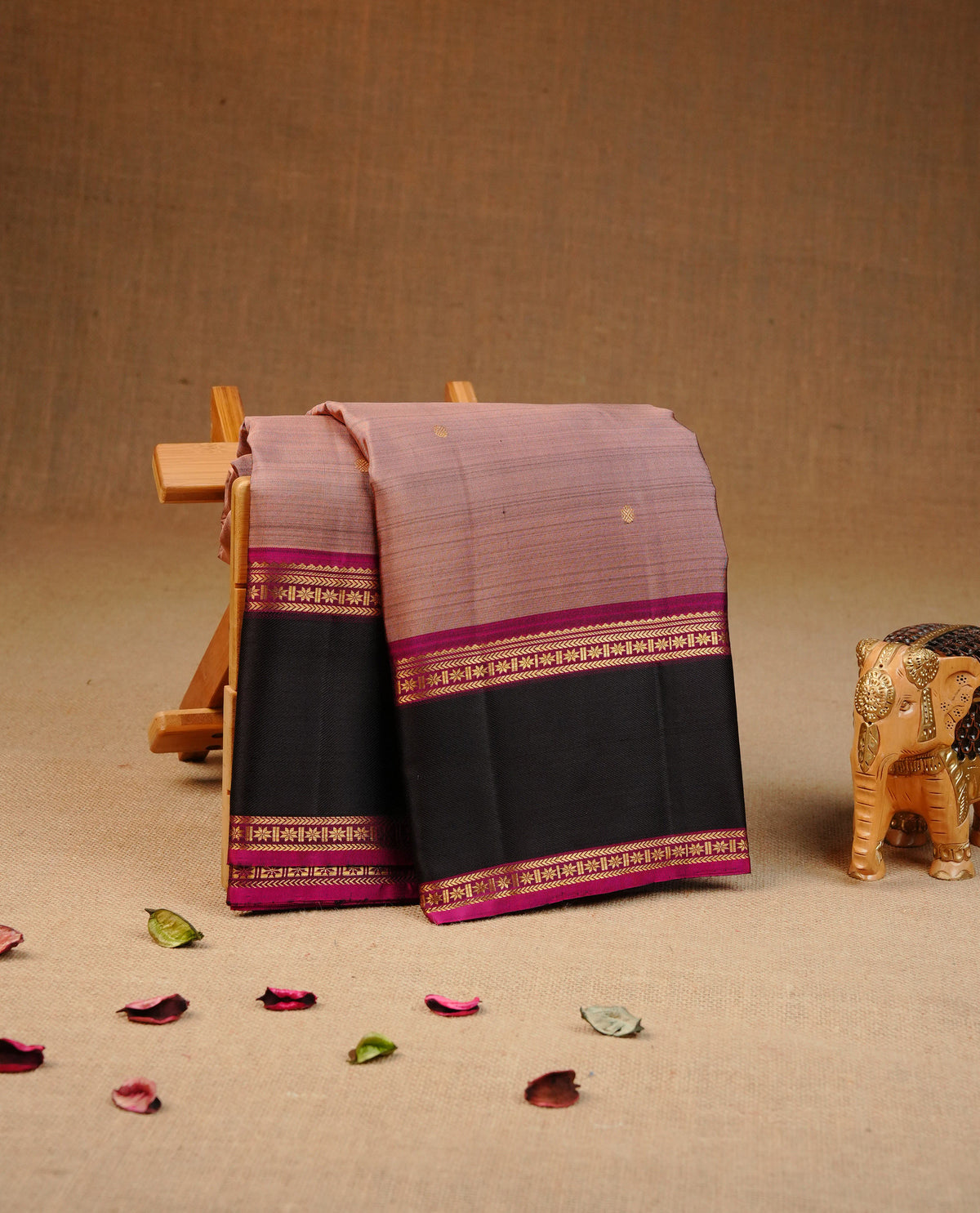 Pinkish beige colour Traditional kancheepuram silk saree featuring Plain body, contrast Black & Purple colour with simple traditional border, comes with matching blouse piece.