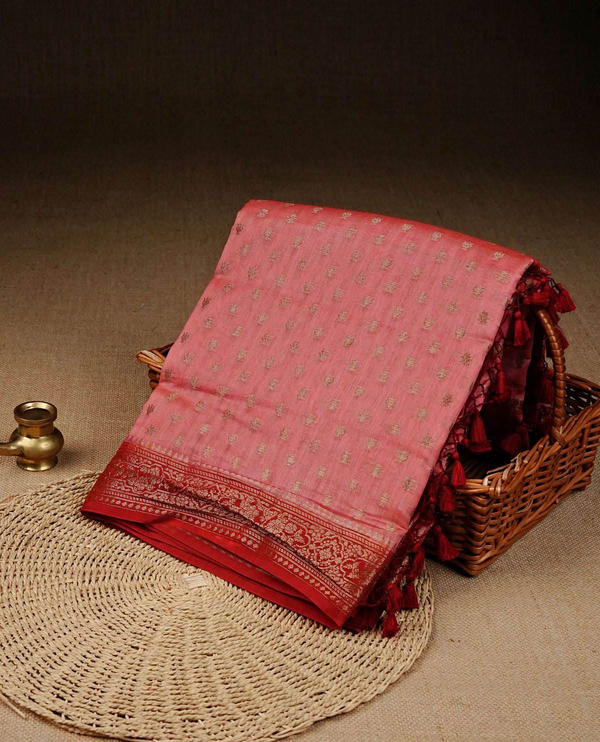 Pink colour banaras saree featuring Gold zari buttas on body, complemented by contrast Maroon colour with simple zari border, comes with matching blouse piece.