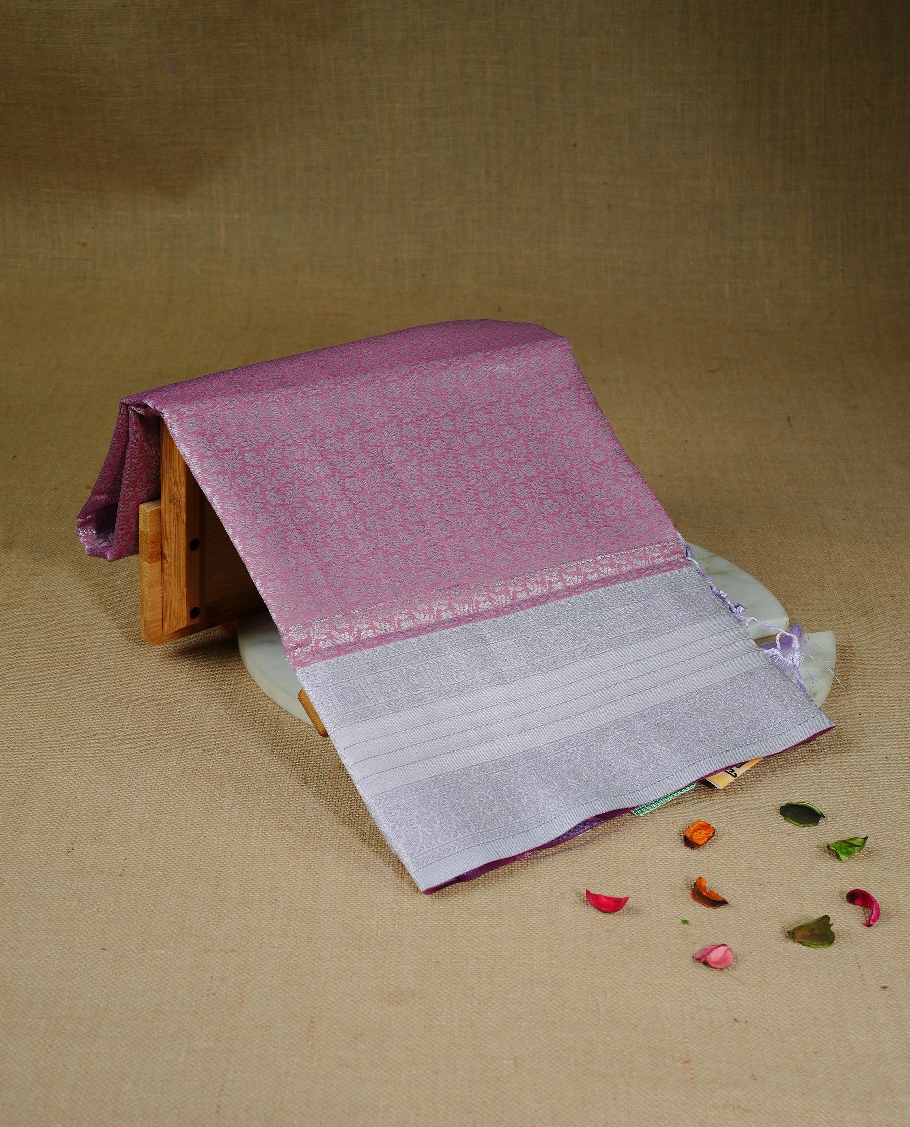 Pink colour semi silk saree featuring Silver zari Floral pattern on body, complemented by contrast Lavender colour with silver zari border, comes with matching blouse piece.