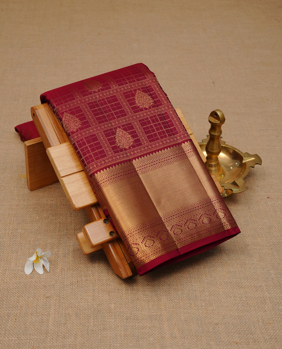 Maroon colour pure wedding silk saree featuring gold zari Box with Motifs on body, complemented by self colour with traditional border, comes with matching blouse piece.