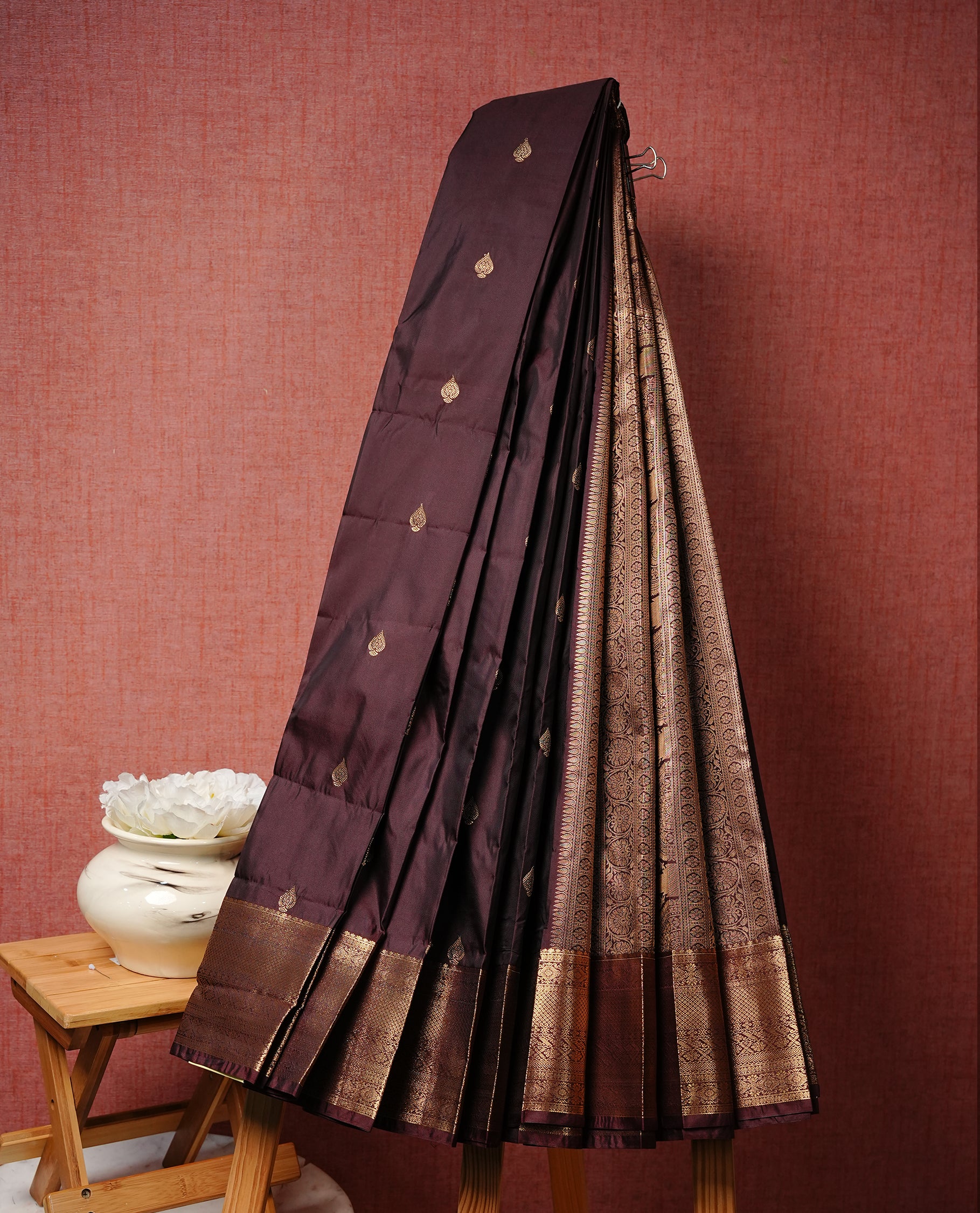 Dark chocolate colour Semi silk saree Featuring gold zari motifs on body, complemented by Self colour with gold zari border, paired with matching blouse piece.