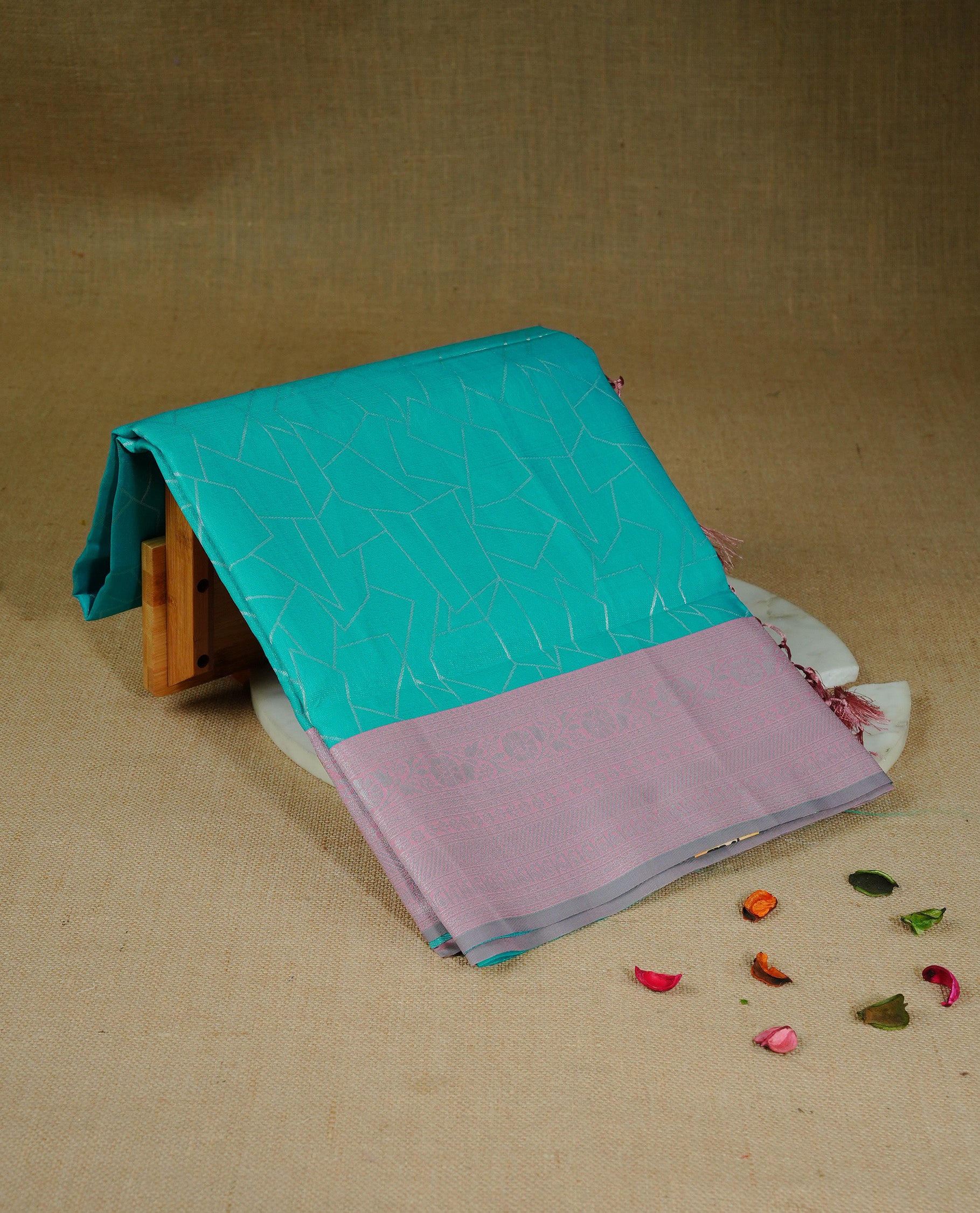 Aqua colour semi silk saree featuring Silver zari Geometric pattern on body, complemented by contrast peach colour with silver zari border, comes with matching blouse piece.