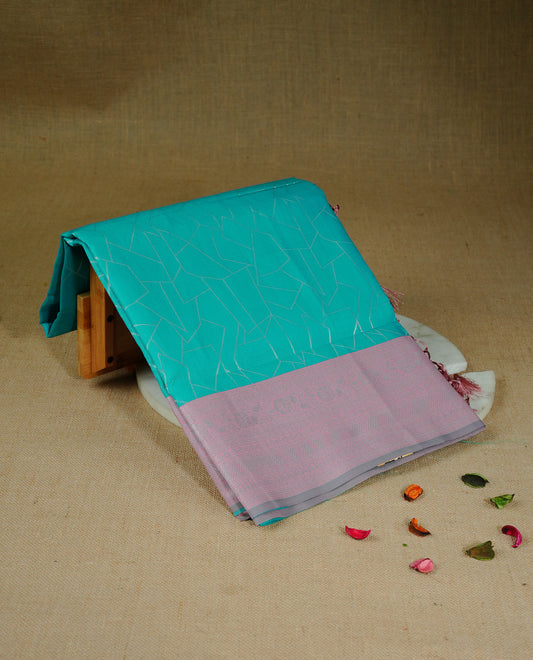 Aqua colour semi silk saree featuring Silver zari Geometric pattern on body, complemented by contrast peach colour with silver zari border, comes with matching blouse piece.