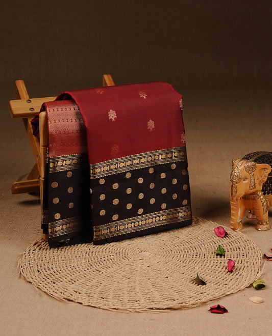 Maroon colour Traditional Kancheepuram silk saree featuring gold zari motifs on body, enhanced with contrast Dark Chocolate with traditional border, paired with matching blouse piece.