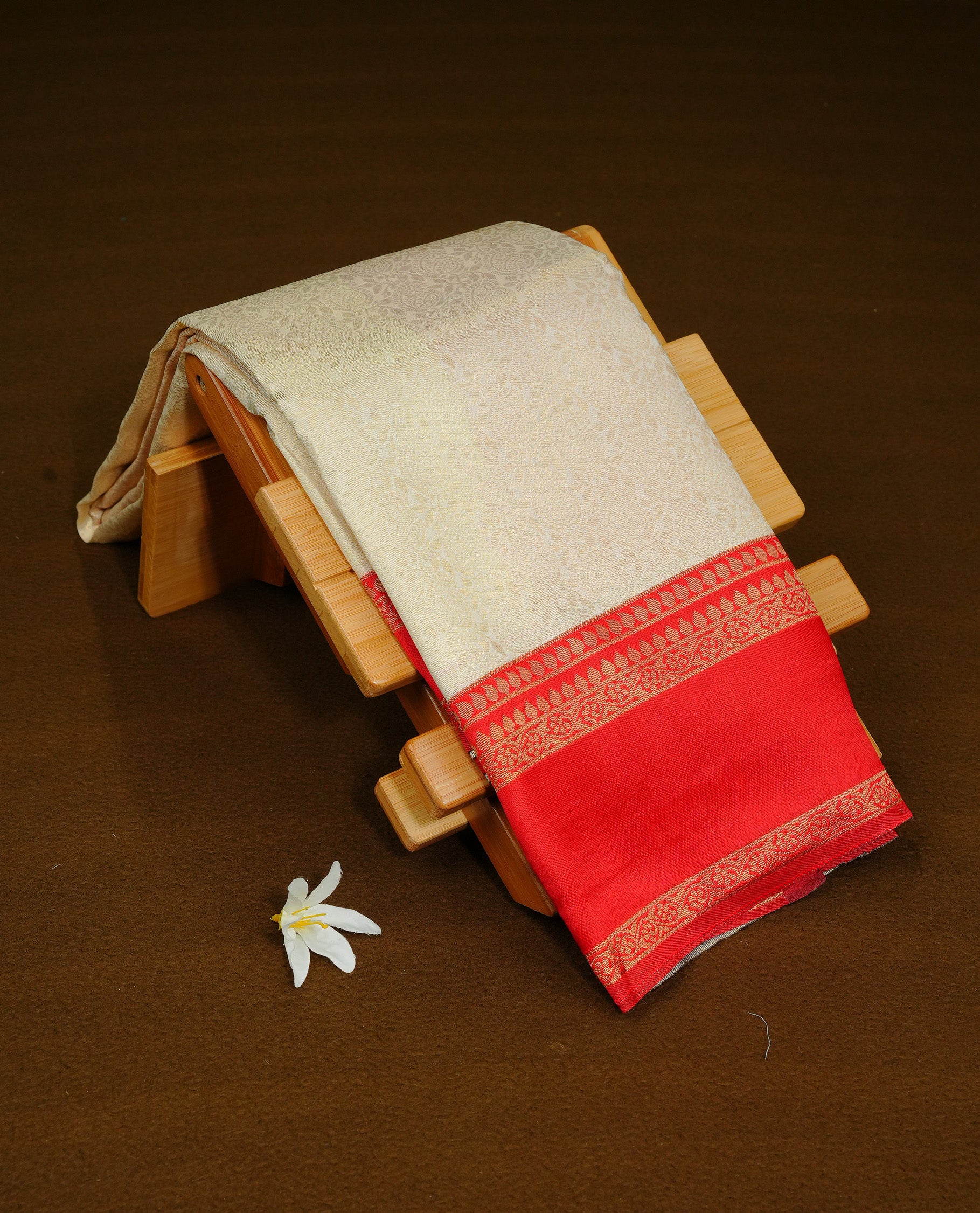 Cream Colour Semi Soft Silk Saree Featuring Gold zari Patter On Body, Highlighted  by contrast Dark red border with Gold zari, paired with matching blouse piece.