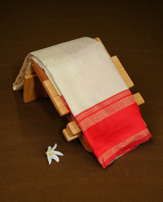 Cream Colour Semi Soft Silk Saree Featuring Gold zari Patter On Body, Highlighted  by contrast Dark red border with Gold zari, paired with matching blouse piece.