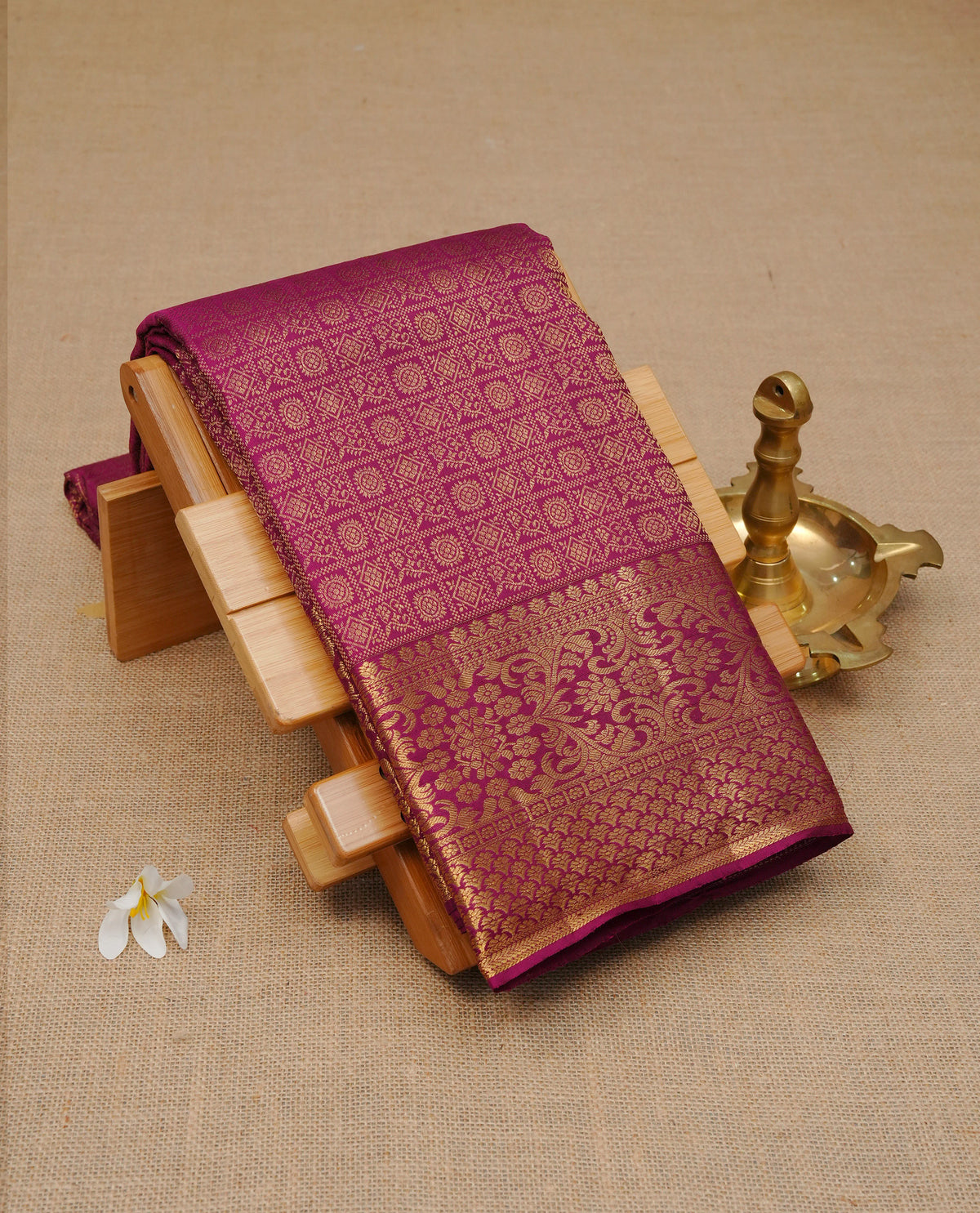 Wine colour Pure wedding silk saree featuring Gold zari Check with motifs on body, complemented by self colour with traditional border, comes with matching blouse piece.