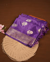 Purple colour Banaras Satin Crepe saree featuring gold zari floral motifs on the body, a richly woven traditional border with intricate gold zari detailing, and paired with a matching blouse.