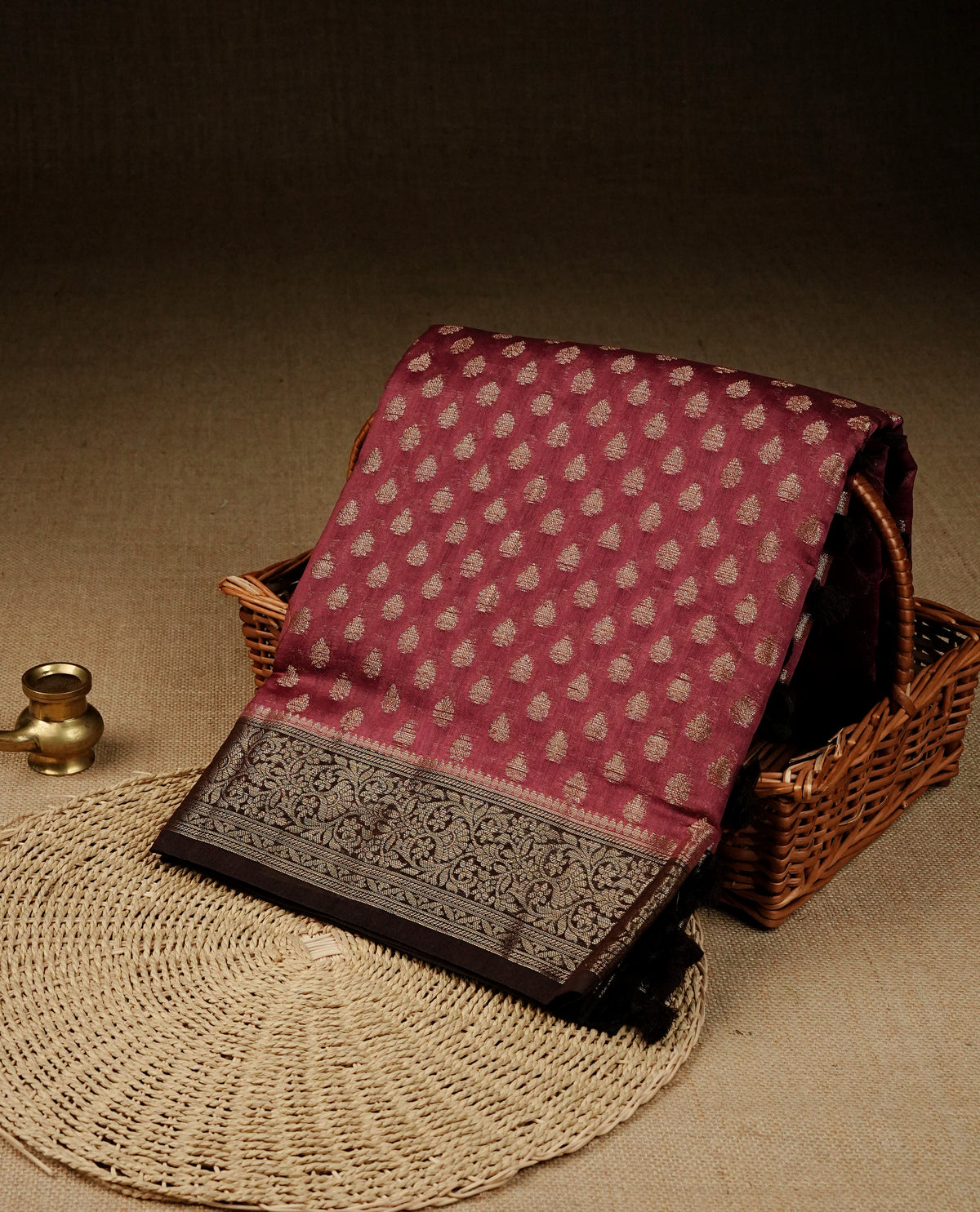 Maroon colour banaras saree featuring gold zari buttas across body, complemented by contrast Chocolate colour with gold zari border, comes with matching blouse piece.
