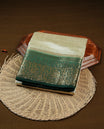 Light gold tussar saree featuring Elegant plain body, complemented by contrast dark green colour with Gold zari Floral kodi with Elephant Pattern border, comes with matching blouse piece.