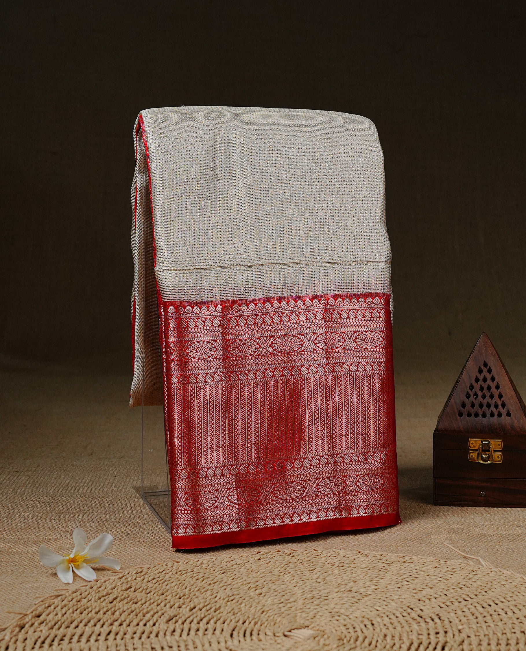 Creamy colour Net Tissue saree Elegant plain body, complemented by Red colour with Light gold zari traditional border, paired  with matching blouse piece.