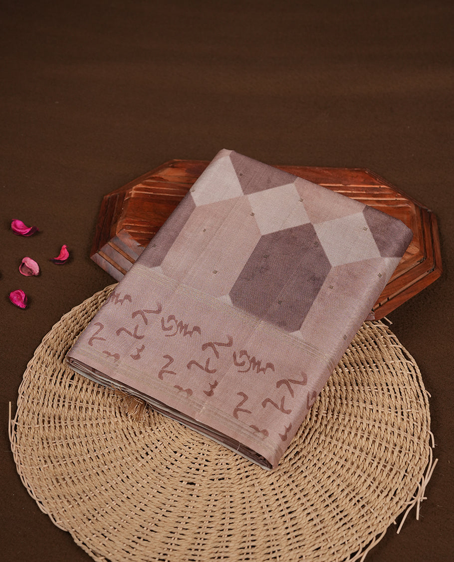 Light brown colour semi tusser silk saree featuring geometric print pattern across body, gold zari border with style motifs and paired with matching blouse.