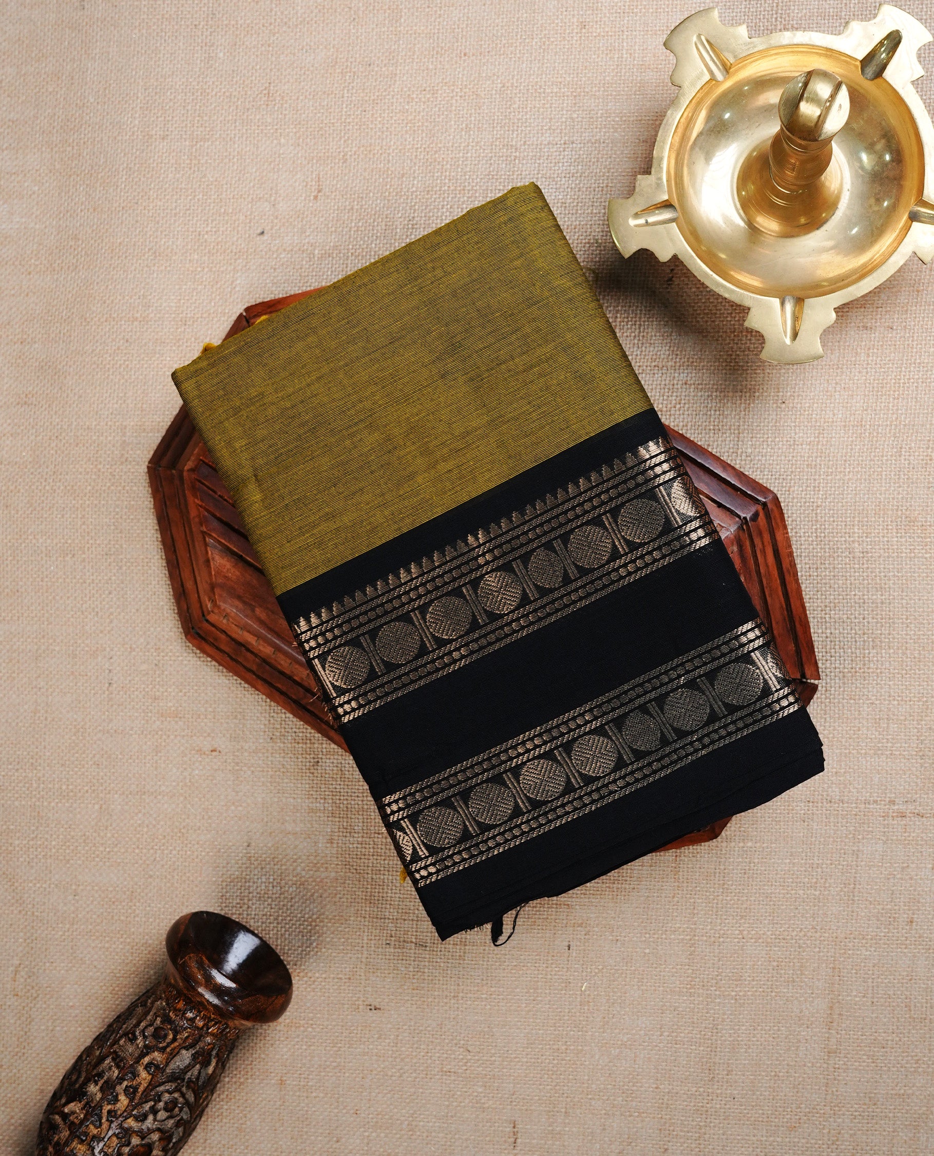 Olive colour chettinad cotton saree featuring Elegant plain body, complemented by contrast Black colour with Gold zari border, paired with matching blouse piece.