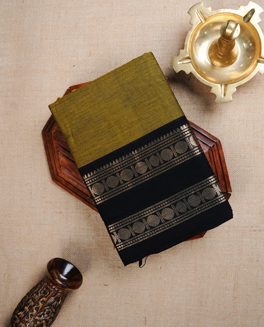 Olive colour chettinad cotton saree featuring Elegant plain body, complemented by contrast Black colour with Gold zari border, paired with matching blouse piece.