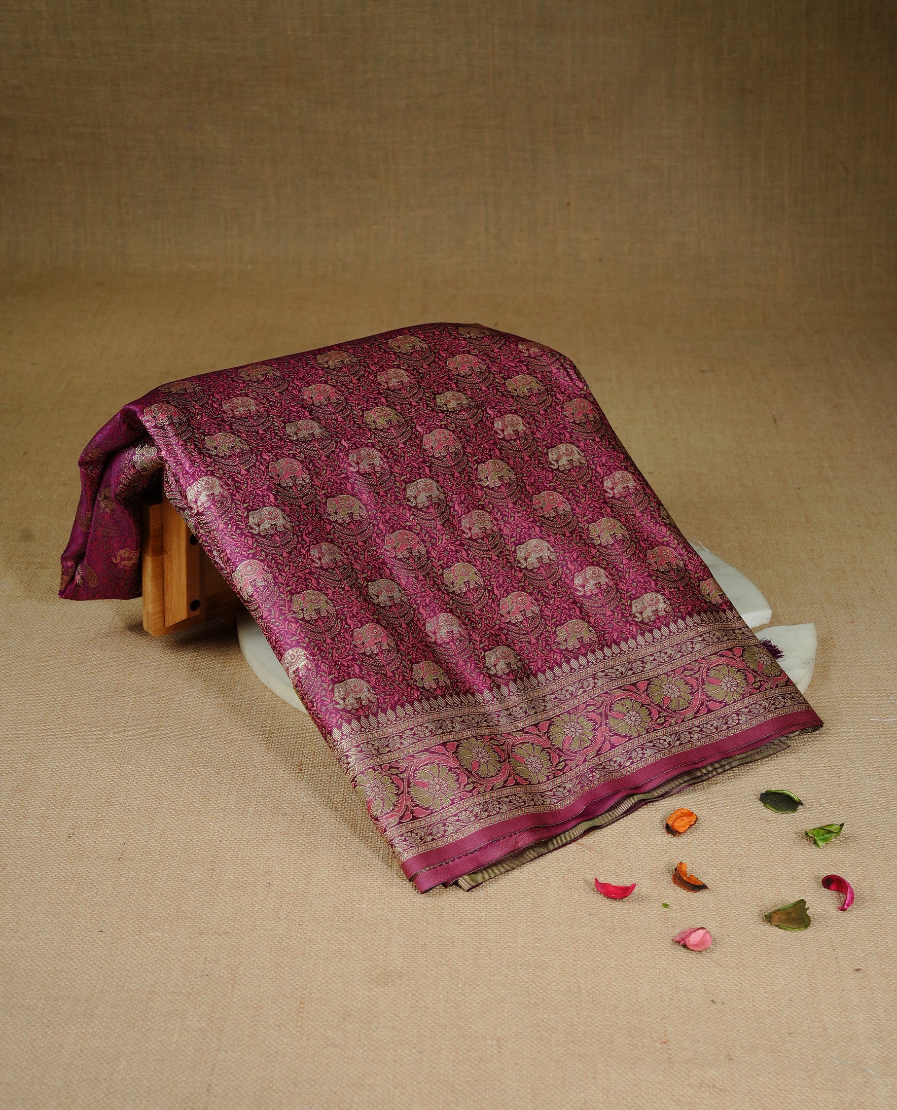 Maroon colour Mulberry silk saree featuring gold zari elephant & floral kodi pattern across body, complemented by self colour border with gold zari work, comes with matching blouse piece.