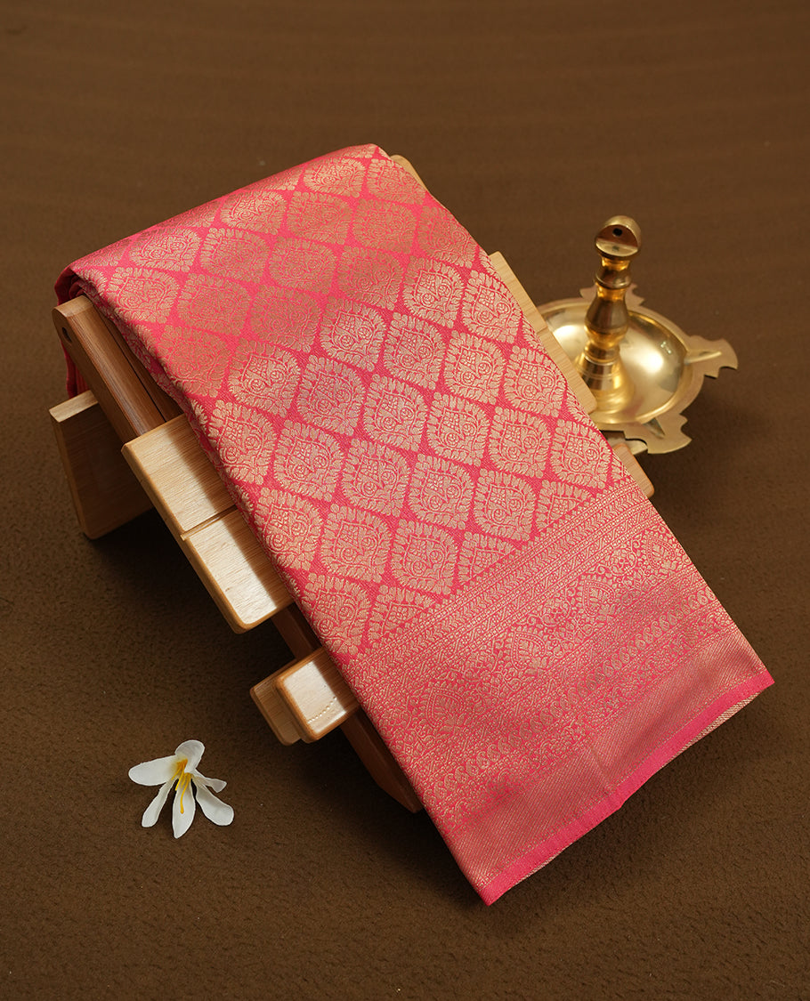 Watermelon colour semi silk brocade saree featuring intricate Gold butta patterns across the body, complemented by a rich self colour woven border and pallu, paired with a matching blouse.