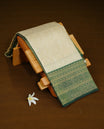 Cream Colour Semi Soft Silk Saree Featuring Gold zari Check With motifs Pattern On Body, Highlighted  by contrast Green border with Gold zari, paired with matching blouse piece.