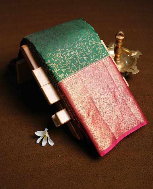 Green colour semi wedding saree featuring Gold zati floral kodi pattern on body, complemented by contrast magenta with traditional border, paired with matching blouse piece.