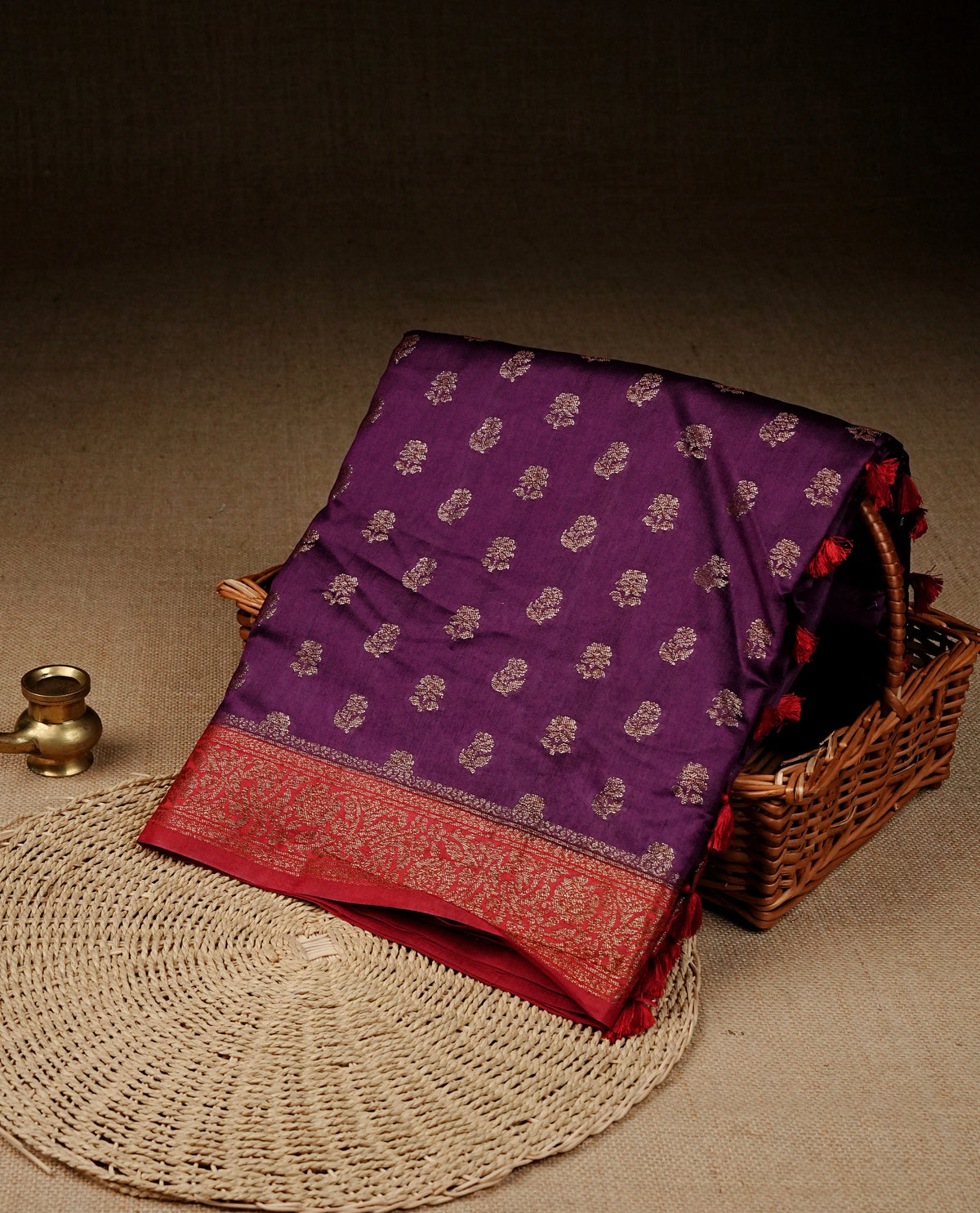 Purple colour banaras saree featuring Gold zari buttas on body, complemented by contrast Maroon colour with simple zari border, comes with matching blouse piece.