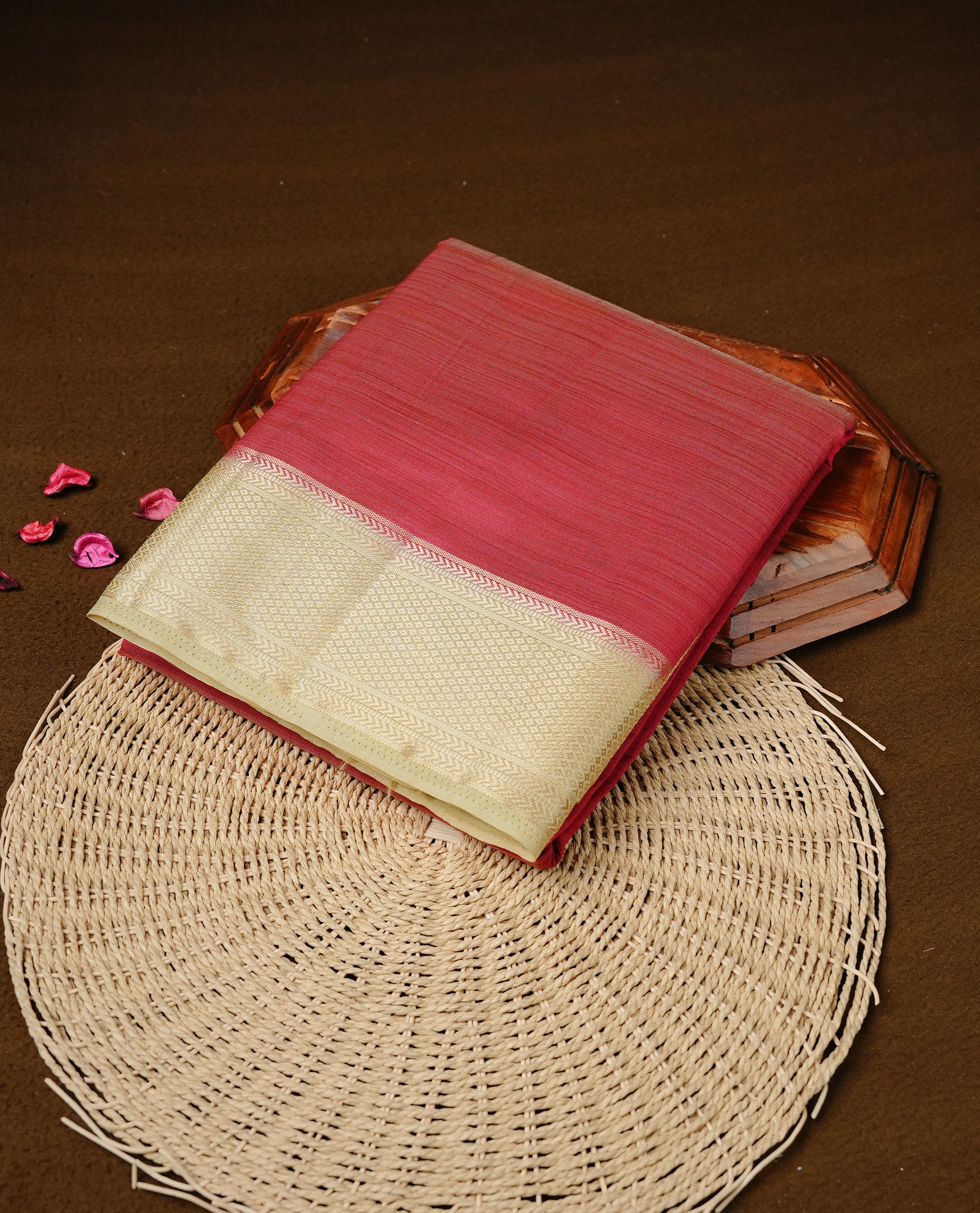 Red colour Semi Tussar silk saree featuring an elegant plain body, accentuated by a contrast cream border adorned with intricate gold zari work, paired with a matching blouse piece.