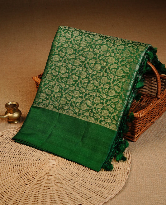 Green  colour pure tussar silk saree featuring light gold zari floral kodi work on the body, a plain border, grand pallu, Paired With  a matching blouse piece.
