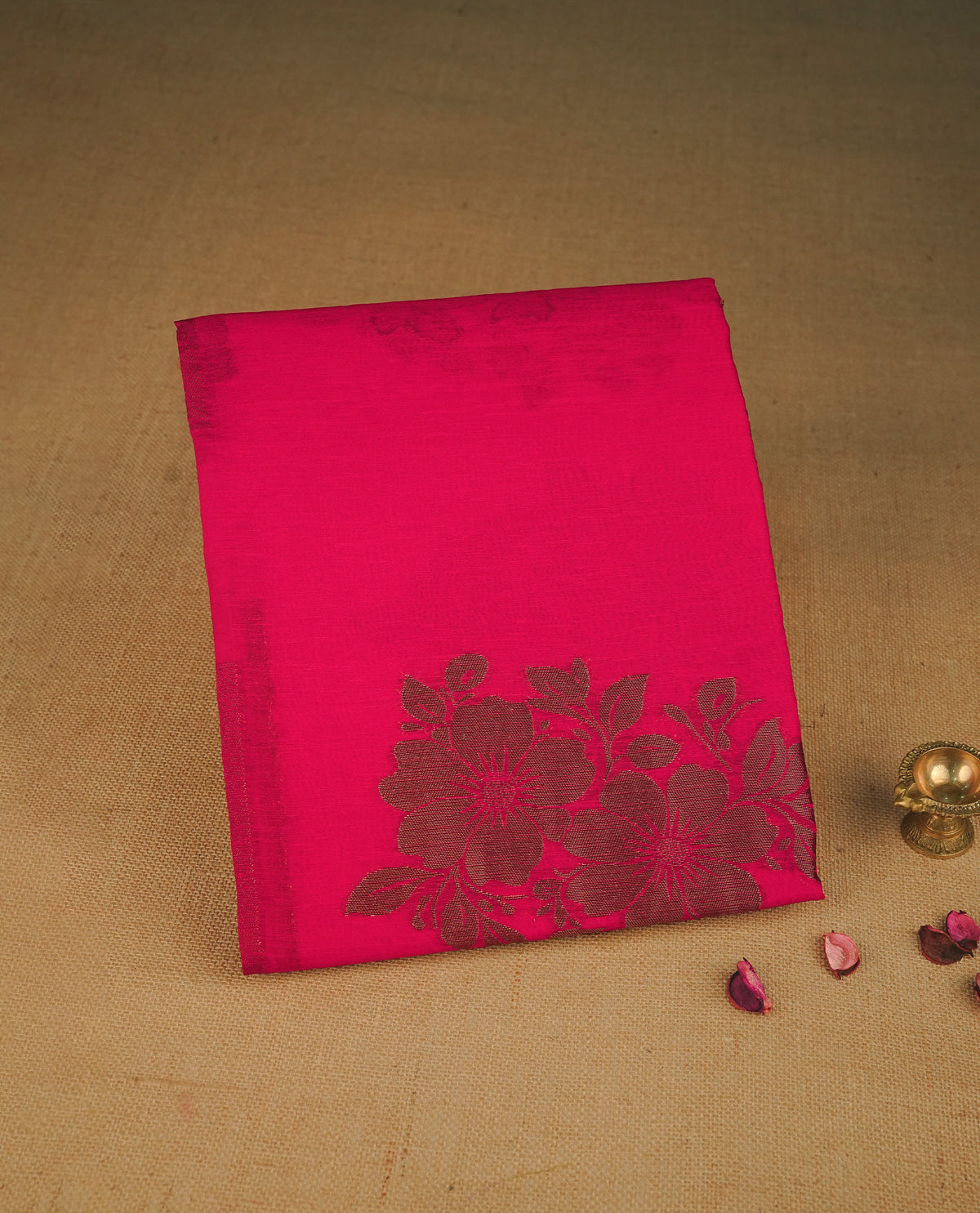 Rani pink colour semi linen saree with elegant gold zari floral motifs across the body, complemented by a contrast colour with grand gold zari pallu and a borderless design, paired with a matching blouse piece.